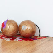 Jacqueline Surdell, Gilded Sphere (school spirit) I - VI, soccer ball, ribbons. Photo by Ian Vecchiotti
